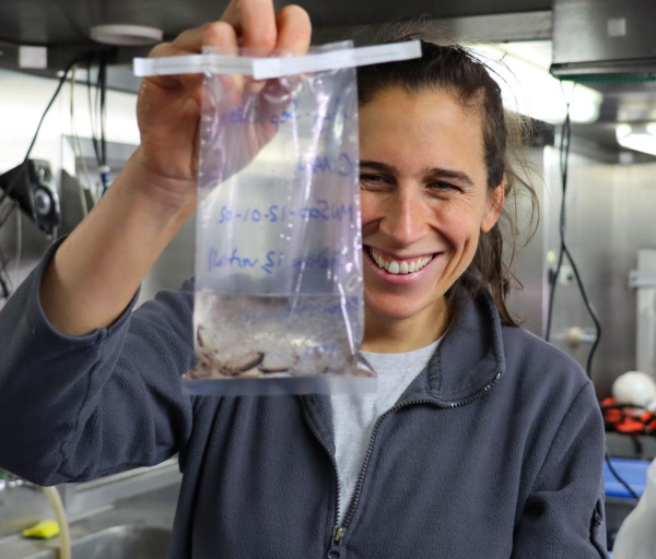 A woman holding a plastic scientific sample bag